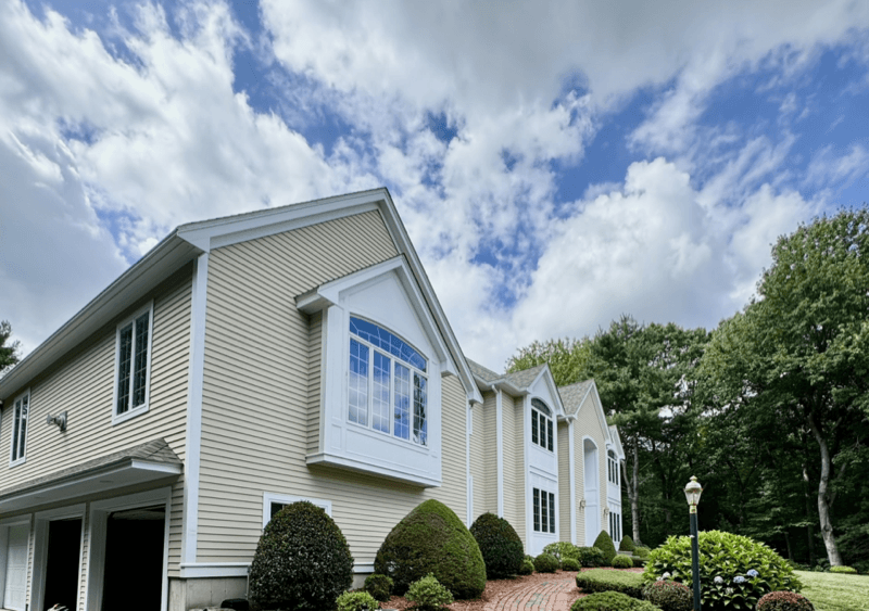 Exterior painting on a colonial home with beige siding and white trim in North Andover, MA
