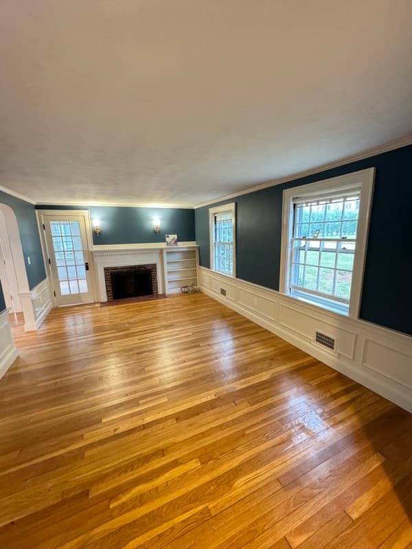 Living room with teal walls, white crown molding, and hardwood floors in Lynnfield, MA