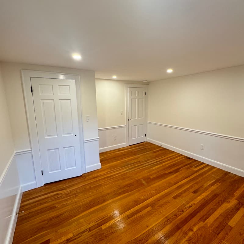 Painted room with off-white walls, wainscoting, and hardwood floors in Lynnfield, MA
