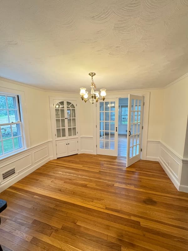 Foyer with freshly painted white walls, French doors, and transom window in Lynnfield, MA