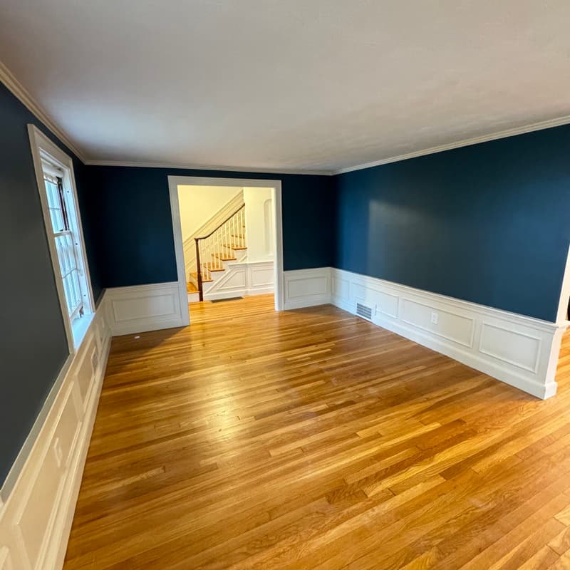Formal room with dark navy walls and white wainscoting in Lynnfield, MA